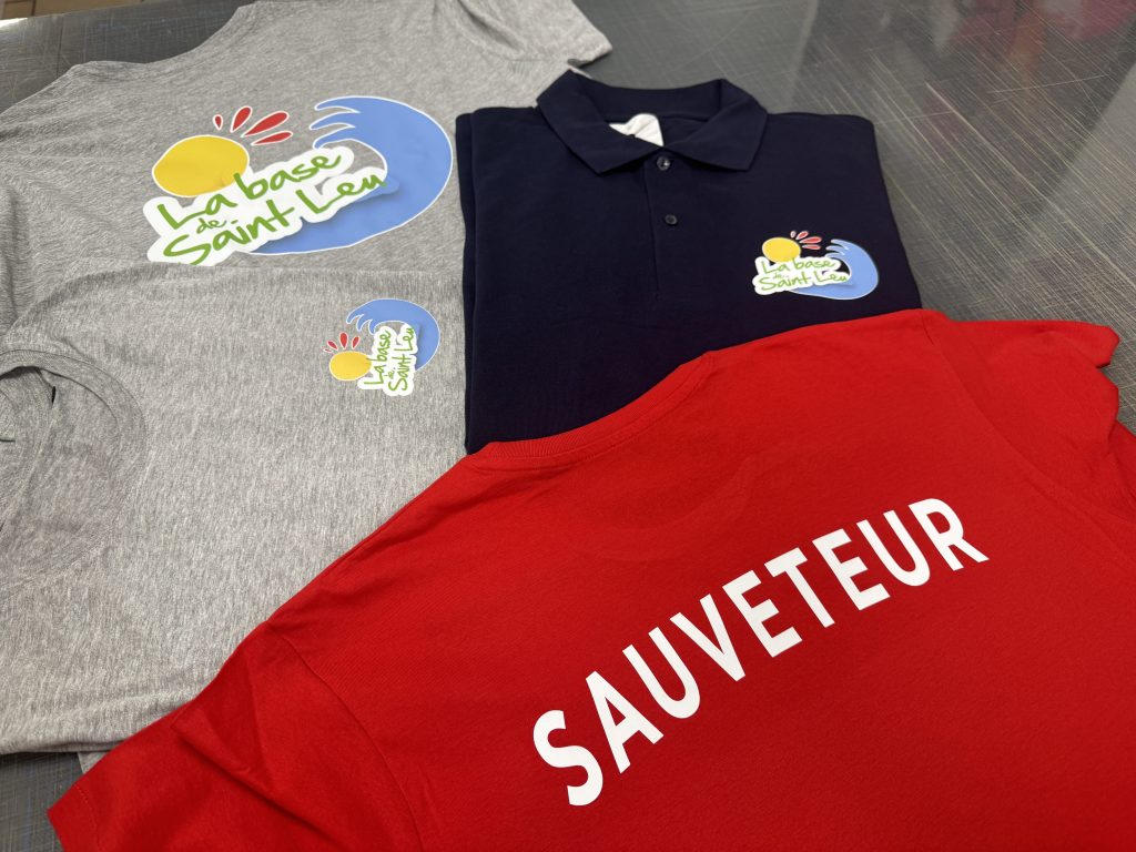 Tee-shirt rouge avec inscription SAUVETEUR en flex, accompagné de vêtements La Base de Saint-Leu