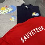 Tee-shirt rouge avec inscription SAUVETEUR en flex, accompagné de vêtements La Base de Saint-Leu
