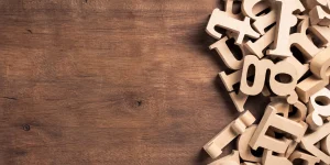 Illustration de lettres découpées en bois sur un fond en bois